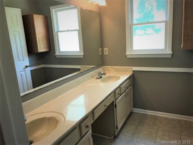 5512 Griffith Road Monroe, NC 28112 - Photo 25 of 36 a bathroom with a sink a mirror and a window