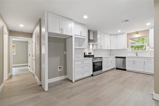 a kitchen with white cabinets and white stainless steel appliances