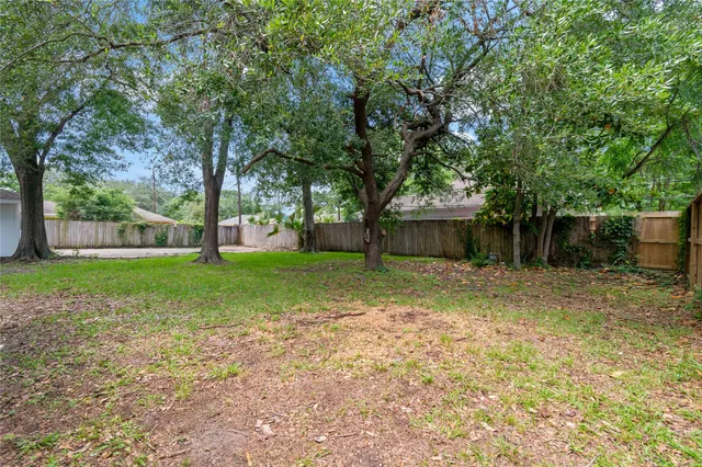a view of a house with backyard and a tree