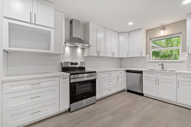a kitchen with granite countertop white cabinets and stainless steel appliances