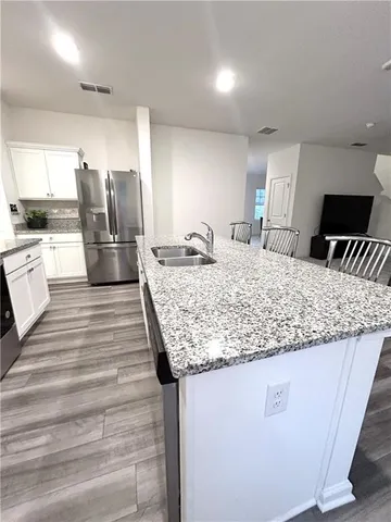 a kitchen with kitchen island granite countertop a sink stove and refrigerator