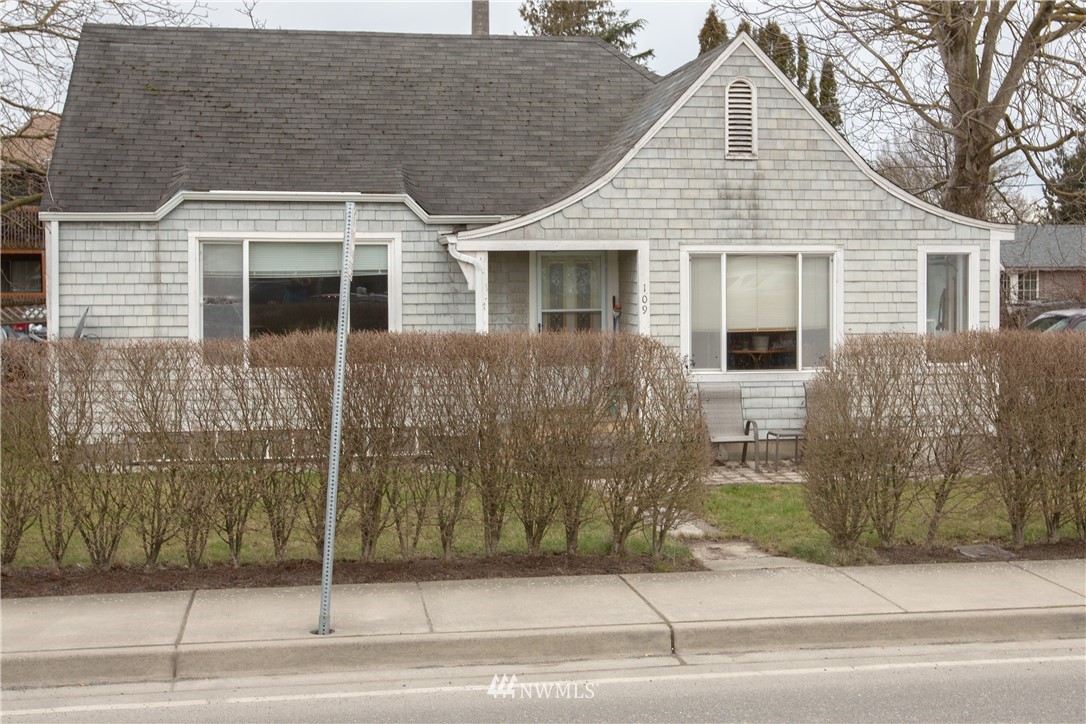 a view of a brick house with a small yard and large window