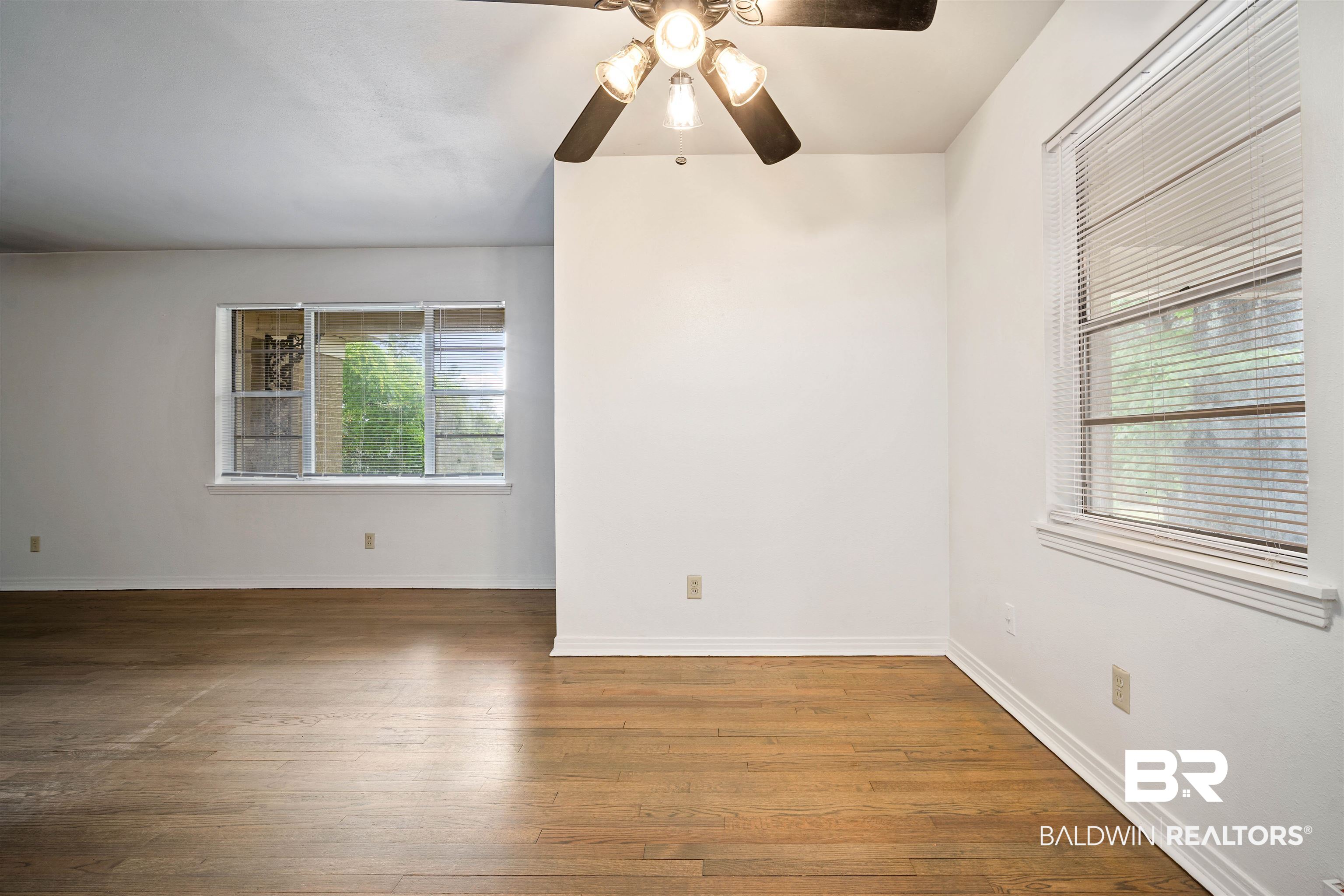 570 Markham Drive Mobile, AL 36609 - Photo 12 of 25 Empty room featuring wood finished floors, a ceiling fan, and baseboards