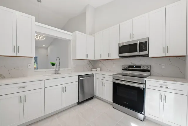 a kitchen with white cabinets and stainless steel appliances