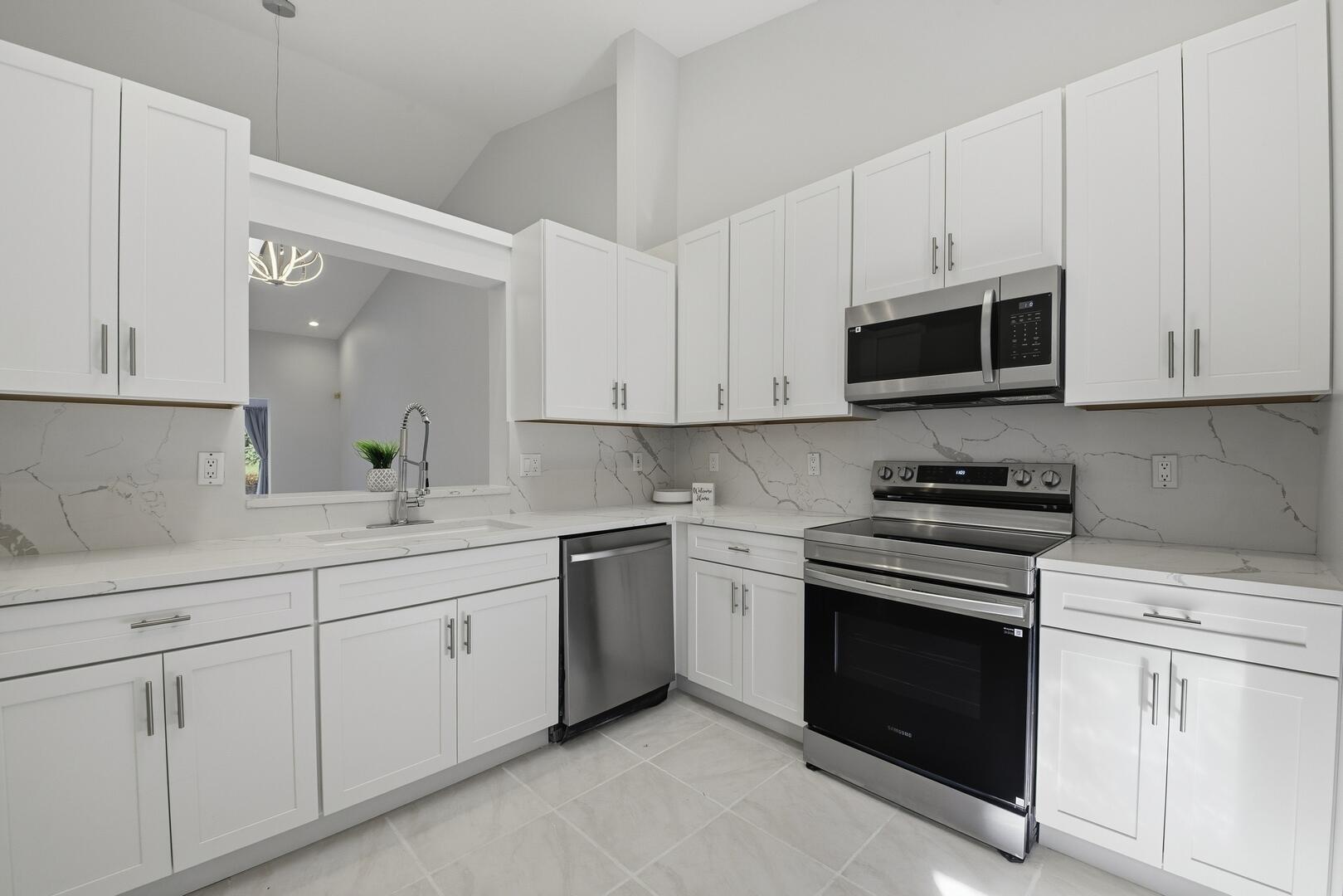 a kitchen with white cabinets and stainless steel appliances