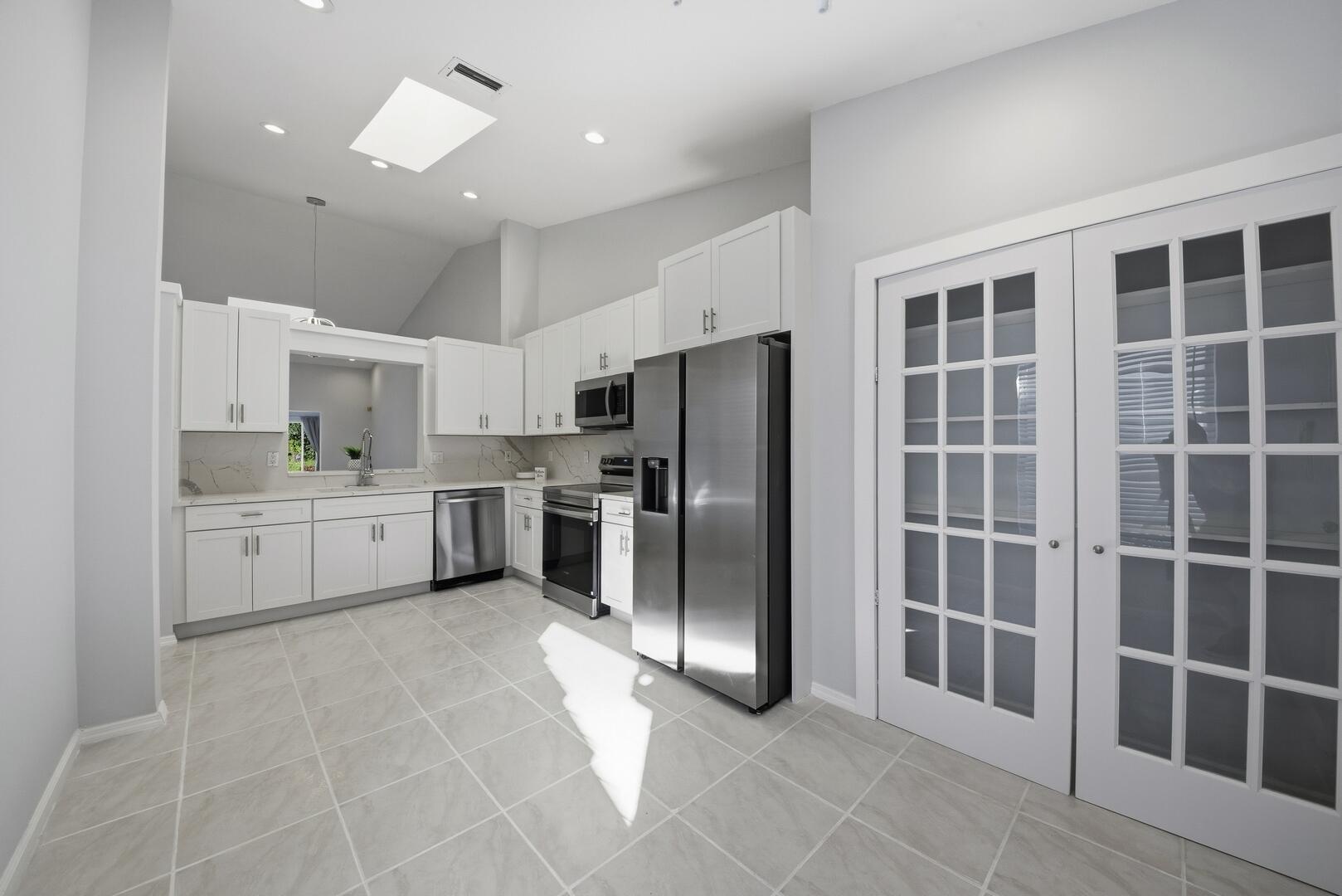 7617 Island Breeze Terrace Boynton Beach, FL 33437 - Photo 12 of 46 a large white kitchen with cabinets a refrigerator and a sink