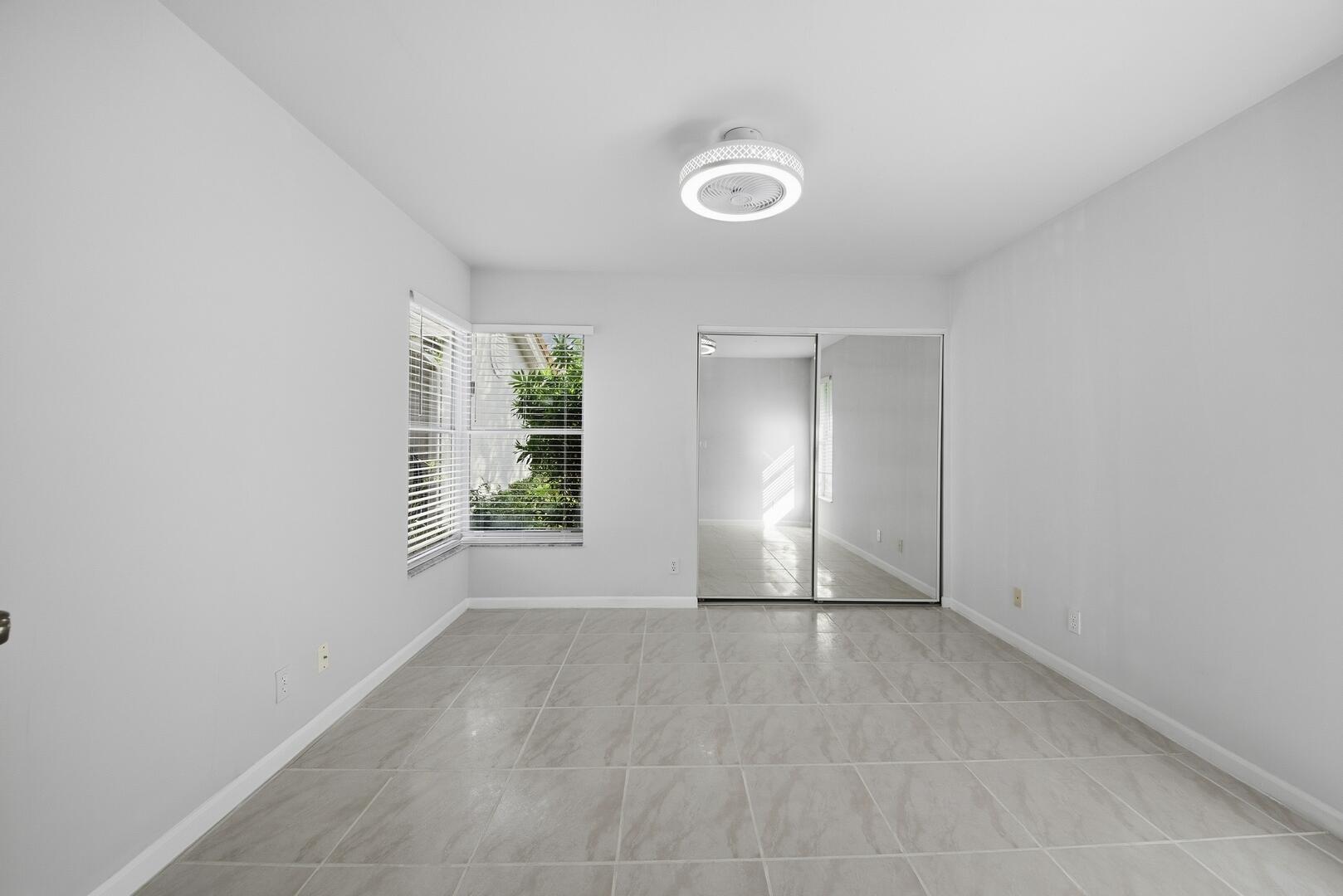 7617 Island Breeze Terrace Boynton Beach, FL 33437 - Photo 3 of 46 a view of an empty room with wooden floor and a window