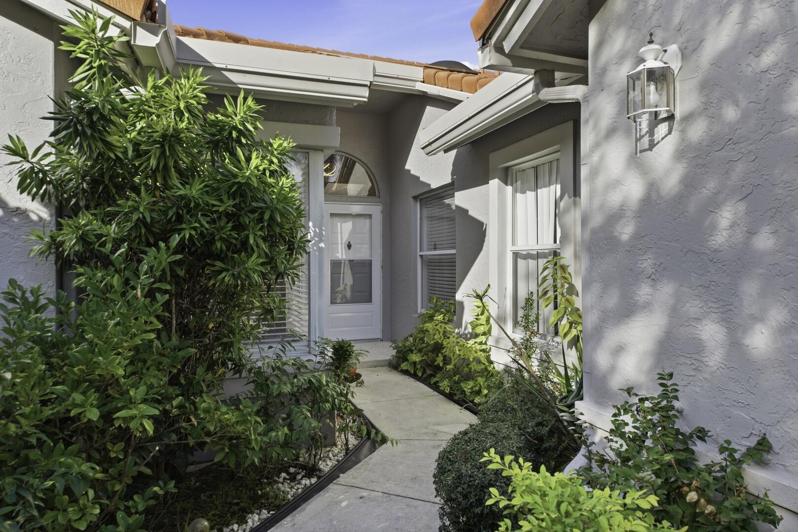 7617 Island Breeze Terrace Boynton Beach, FL 33437 - Photo 45 of 46 a view of a house with plants and entryway