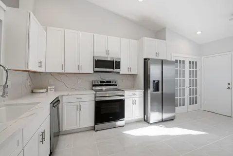 a kitchen with stainless steel appliances granite countertop a refrigerator stove and sink
