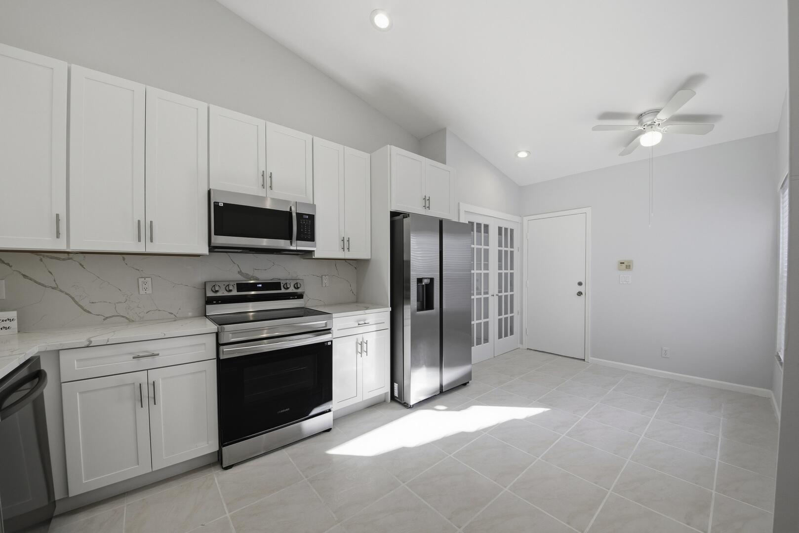 7617 Island Breeze Terrace Boynton Beach, FL 33437 - Photo 9 of 46 a kitchen with stainless steel appliances a stove a sink and a refrigerator