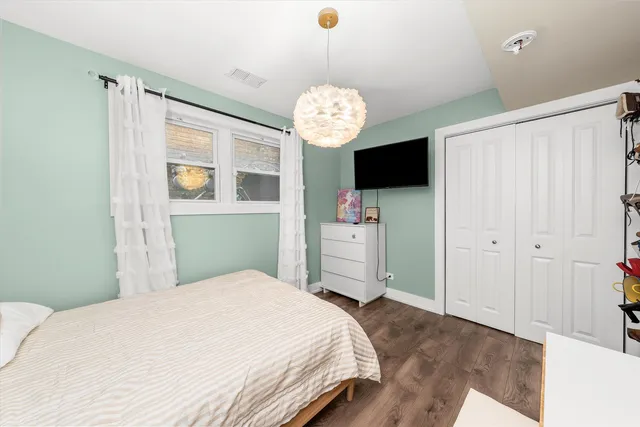 a bedroom with a bed and a chandelier