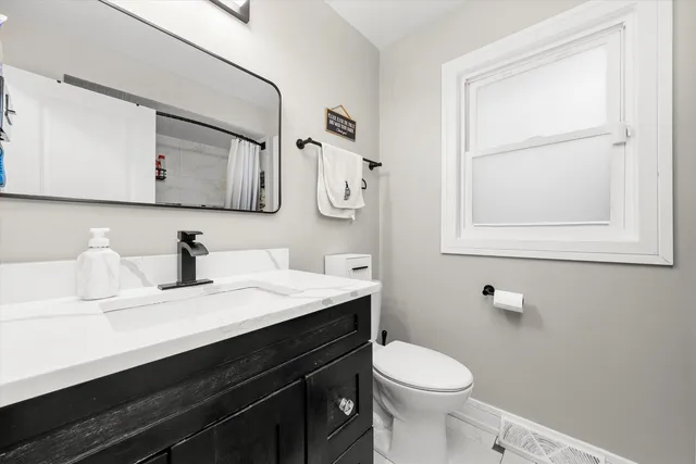 a bathroom with a sink vanity and toilet