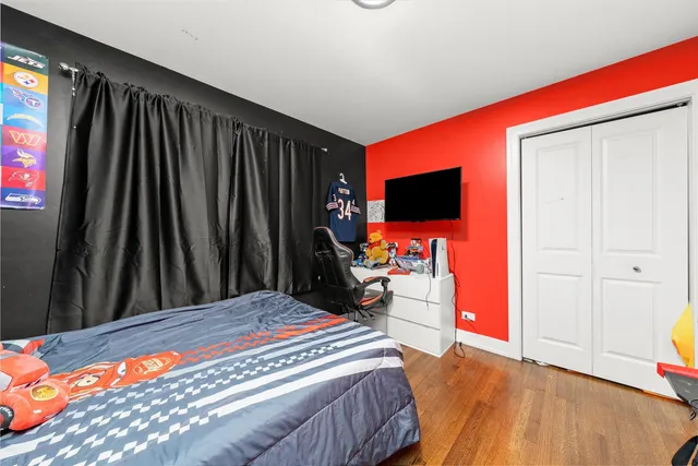 a bedroom with a bed and a flat tv screen on dresser