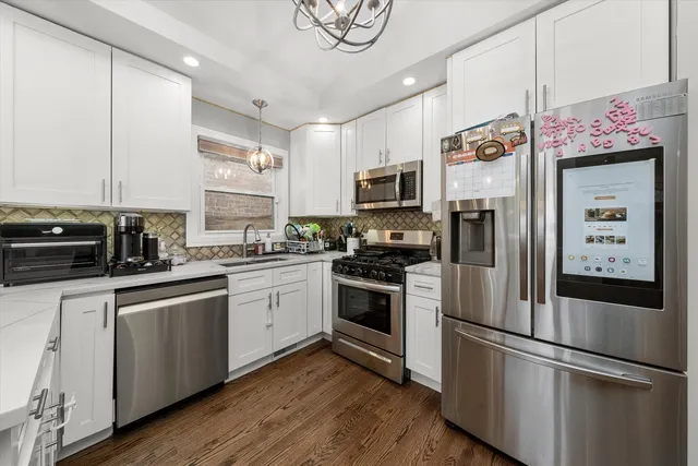 a kitchen with stainless steel appliances and white cabinets