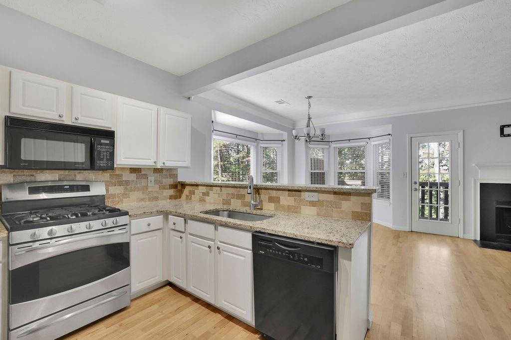 4085 Spring Cove Drive Duluth, GA 30097 - Photo 16 of 45 a kitchen with stainless steel appliances granite countertop a sink stove and cabinets