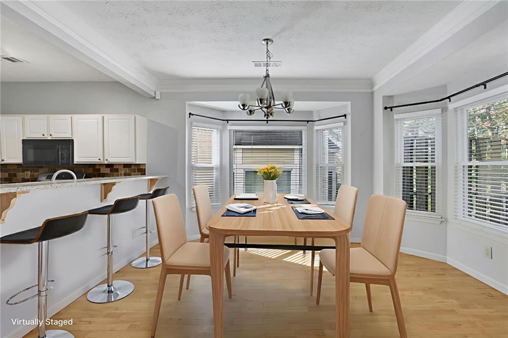 4085 Spring Cove Drive Duluth, GA 30097 - Photo 10 of 45 a dining room with furniture a chandelier and wooden floor