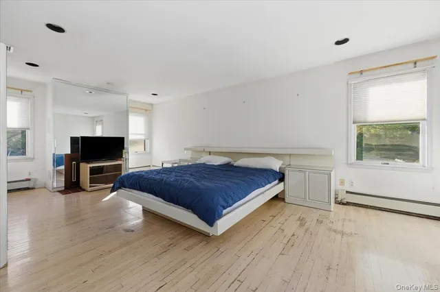 a spacious bedroom with a bed and a flat screen television