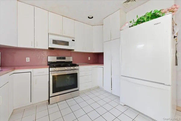 a kitchen with white cabinets and white appliances