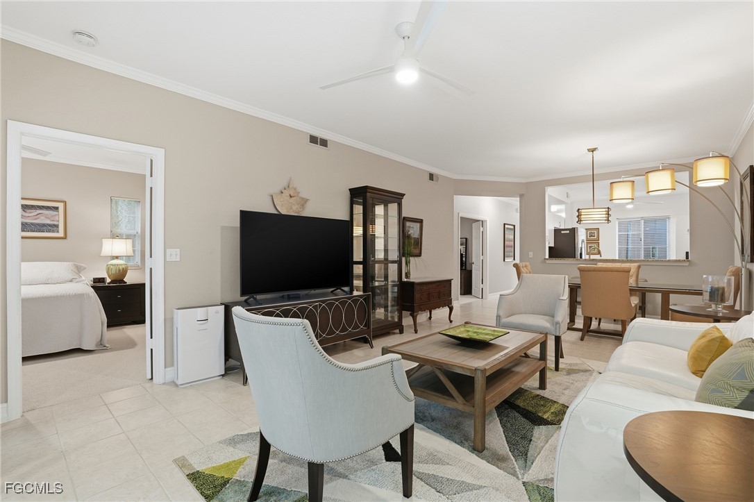 770 Luisa Lane, Unit 3 Naples, FL 34104 - Photo 12 of 38 a living room with furniture a flat screen tv and kitchen view