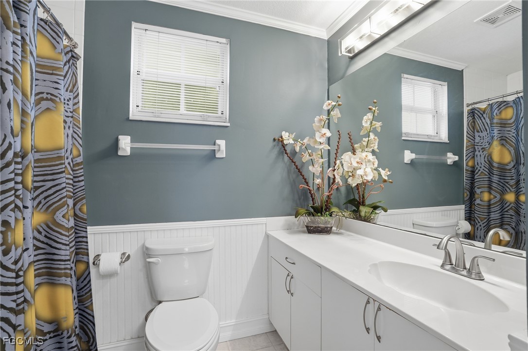 770 Luisa Lane, Unit 3 Naples, FL 34104 - Photo 26 of 38 a bathroom with a sink a toilet and mirror