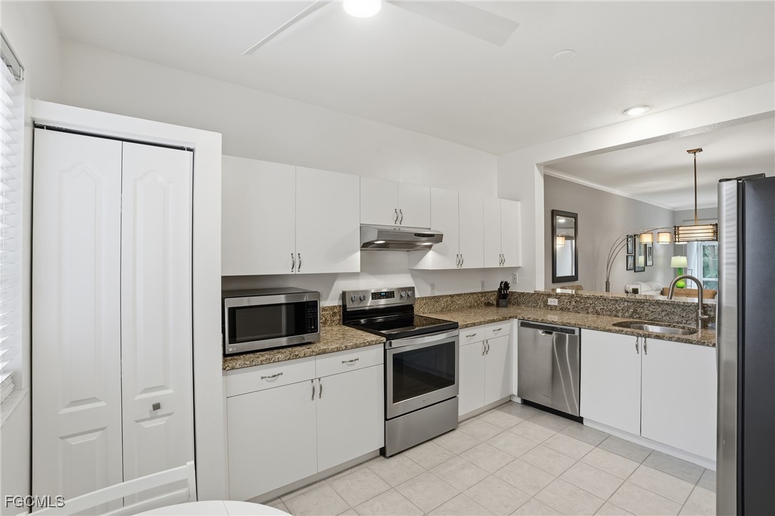 770 Luisa Lane, Unit 3 Naples, FL 34104 - Photo 4 of 38 a kitchen with white cabinets and white appliances