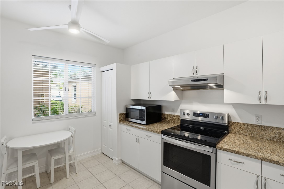 770 Luisa Lane, Unit 3 Naples, FL 34104 - Photo 5 of 38 a kitchen with granite countertop a sink stainless steel appliances and cabinets