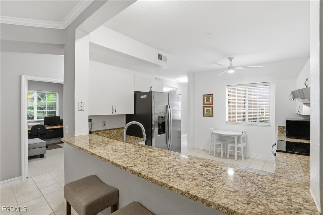 770 Luisa Lane, Unit 3 Naples, FL 34104 - Photo 7 of 38 a kitchen with granite countertop a sink and a refrigerator