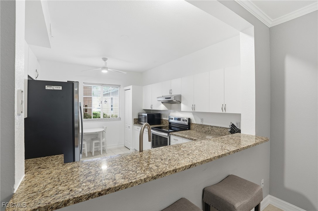 770 Luisa Lane, Unit 3 Naples, FL 34104 - Photo 8 of 38 a kitchen with granite countertop a sink refrigerator and stove