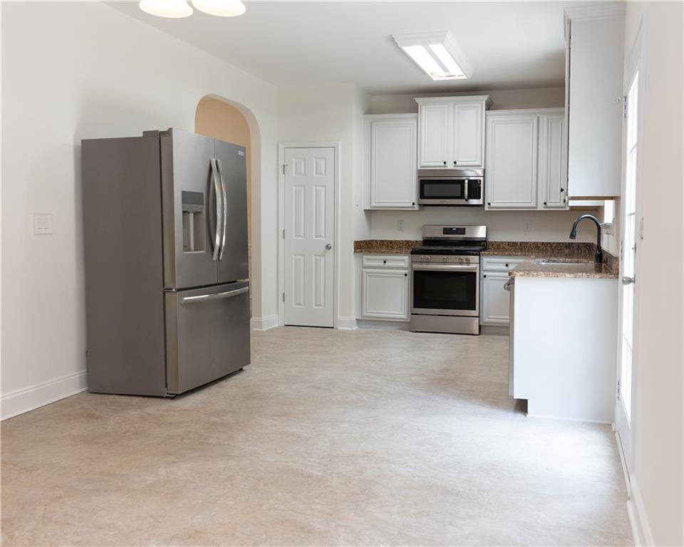 502 Streamside Place Canton, GA 30115 - Photo 10 of 33 a kitchen with stainless steel appliances granite countertop a refrigerator stove and microwave