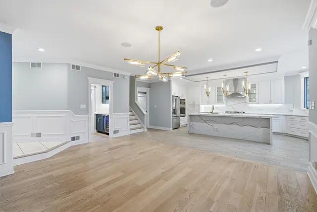 a view of an empty room with a window and kitchen