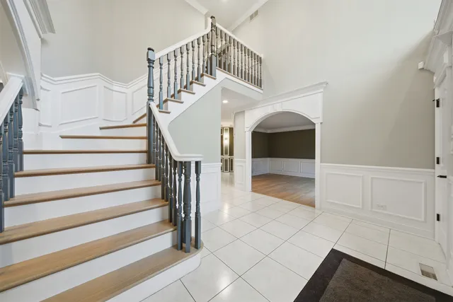 a large kitchen with stainless steel appliances granite countertop a large kitchen island a stove a sink a refrigerator and a dining table with wooden floor