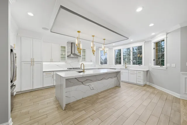 a large white kitchen with a large window and stainless steel appliances