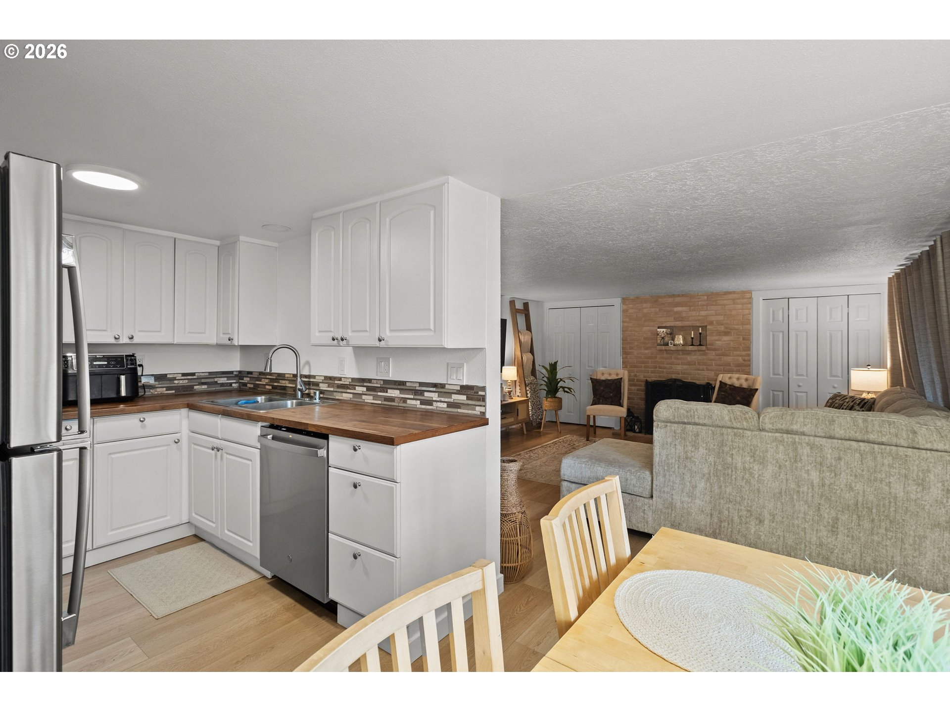 2102 Kelly Road, Unit 9 Vancouver, WA 98665 - Photo 9 of 29 a kitchen with stainless steel appliances granite countertop a stove a sink a refrigerator a dining table and chairs with wooden floor