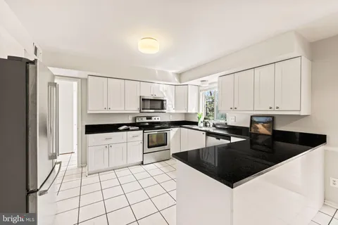 a kitchen with stainless steel appliances a refrigerator and a stove top oven