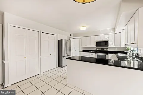 a kitchen with granite countertop a sink a stove top oven and cabinets