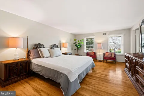 a bed room with a bed a dresser and a wooden floor