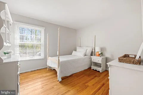 a bedroom with a bed and a dresser next to a window