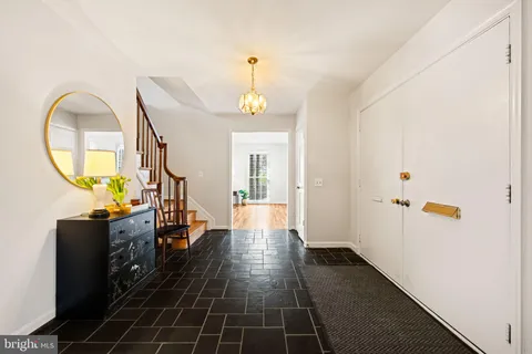 a view of entryway and hall with dining room and wooden floor