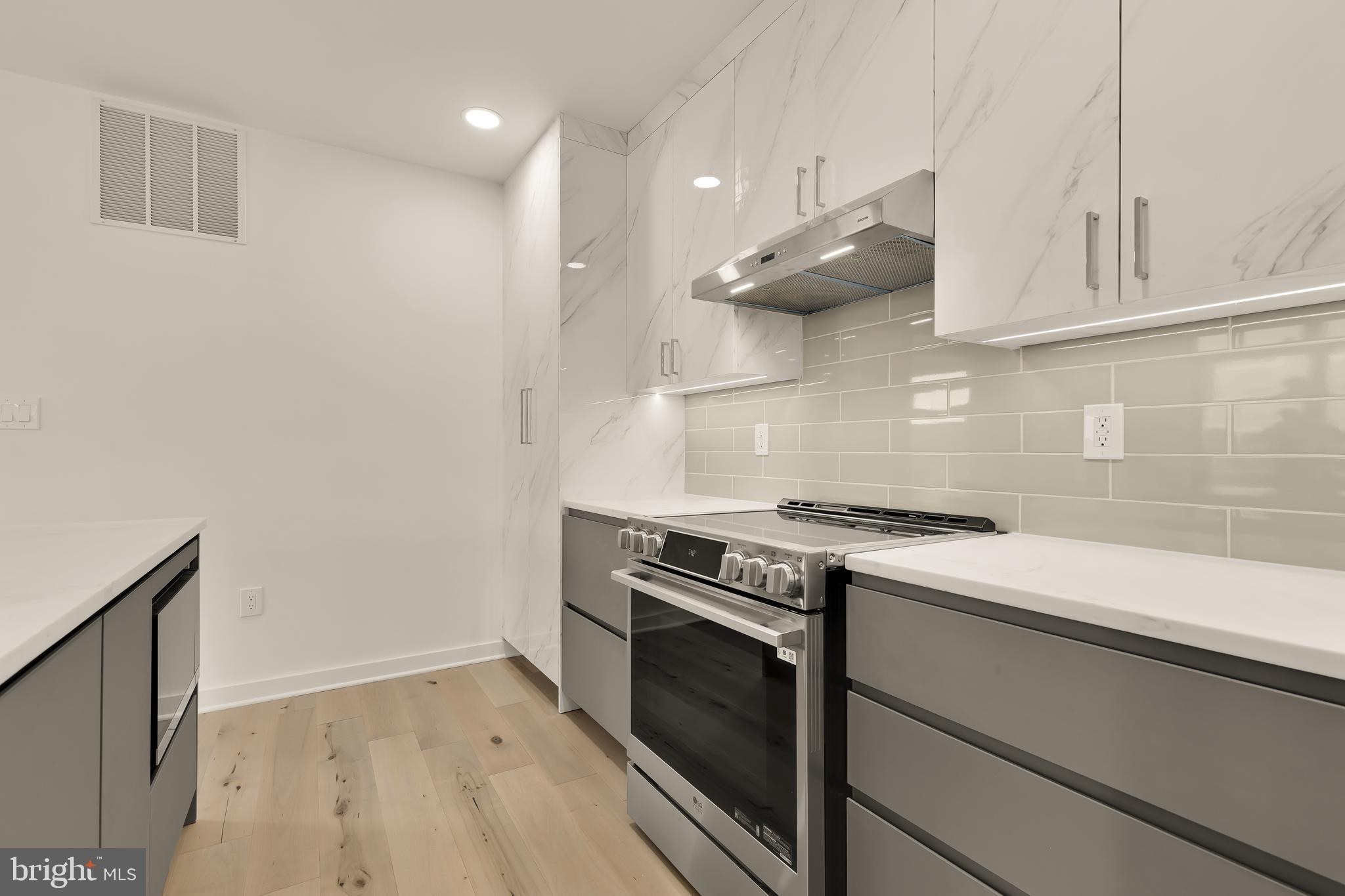 641 Quebec Place Northwest, Unit 1 Washington, DC 20010 - Photo 11 of 30 a kitchen with granite countertop a stove and a sink with cabinets