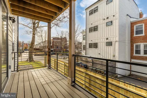 a view of a balcony with wooden floor and iron stairs