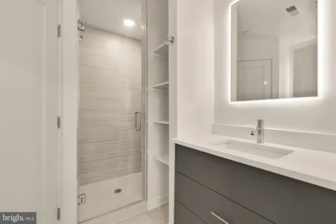 a bathroom with a shower sink and mirror