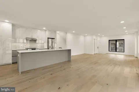a view of kitchen with kitchen island white cabinets and stainless steel appliances