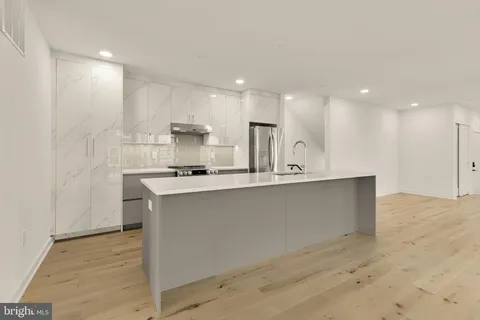 a large kitchen with kitchen island a sink stainless steel appliances and cabinets