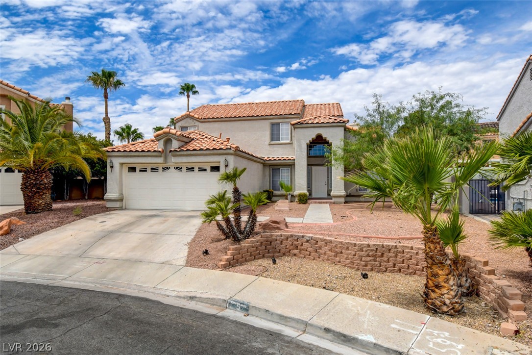 5 Tarryall Terrace Henderson, NV 89074 - Photo 1 of 44 A well-kept front yard showcases desert landscaping and mature palm trees.