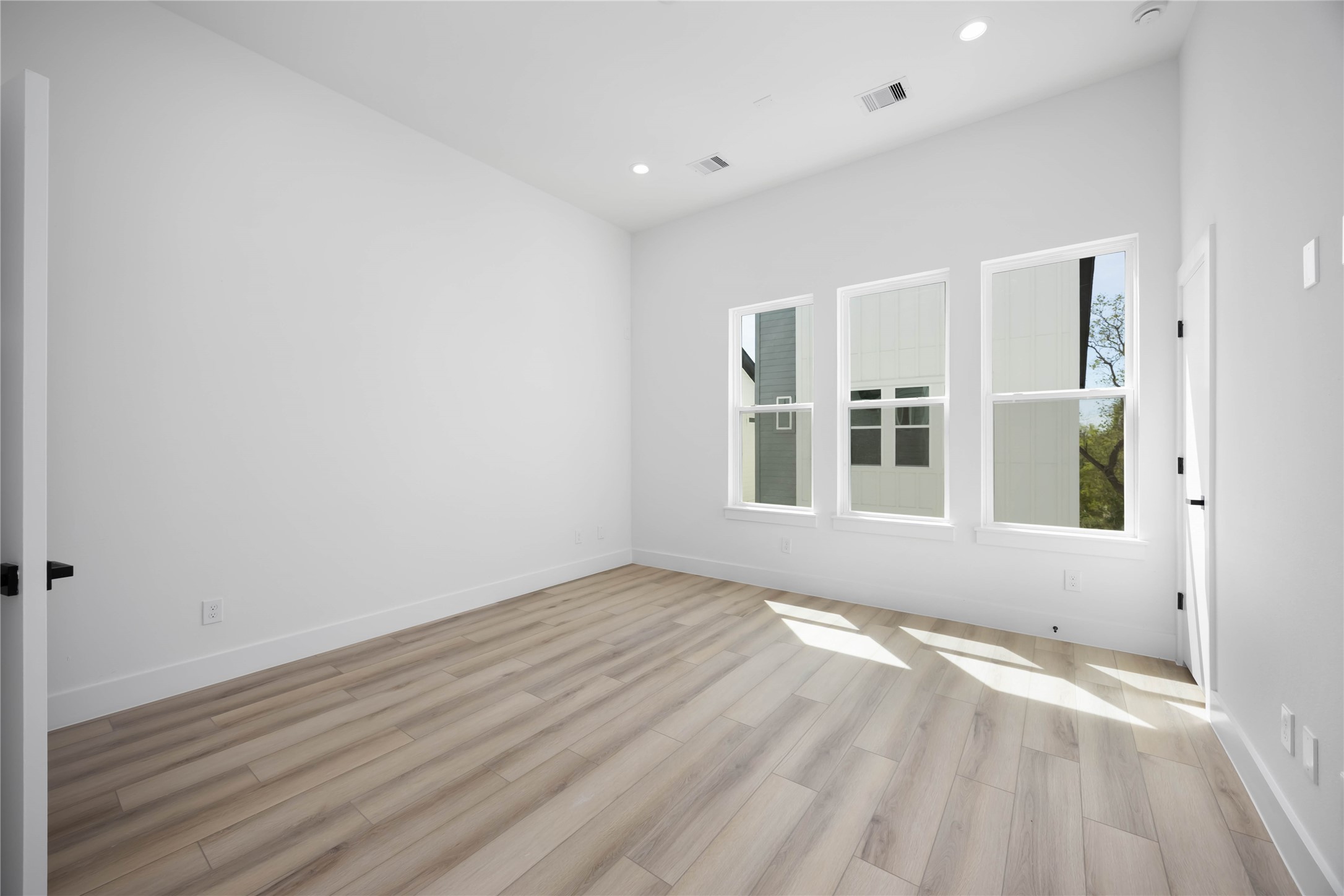 6735 Peerless Street, Unit C Houston, TX 77021 - Photo 14 of 27 an empty room with wooden floor and windows