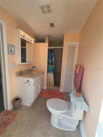 a bathroom with a granite countertop toilet sink and mirror