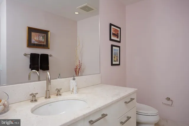 a bathroom with a toilet a sink and mirror
