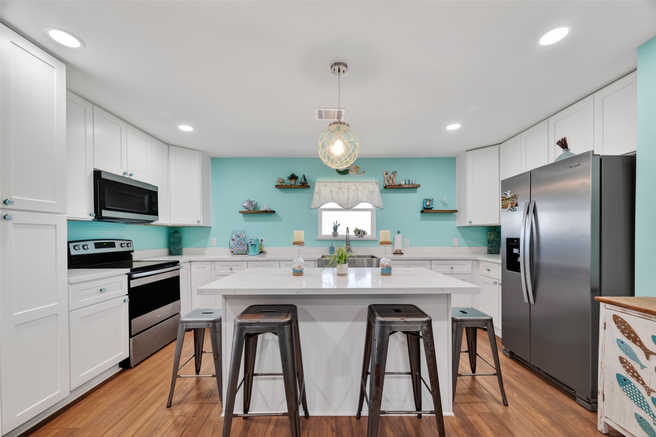 154 Poop Deck Lane Freeport, TX 77541 - Photo 5 of 32 a kitchen with stainless steel appliances kitchen island granite countertop a dining table and chairs in it