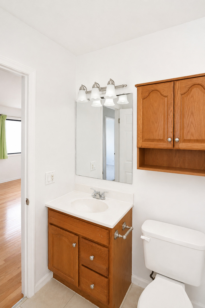 707 Sunfish Point, Unit 707 Schaumburg, IL 60194 - Photo 19 of 20 a bathroom with a toilet sink and mirror