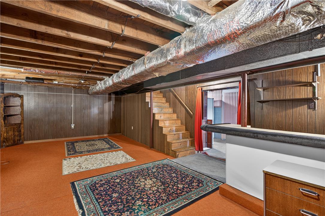 23 Harrison Street Emmaus, PA 18049 - Photo 23 of 28 A partially finished basement offers a versatile space, featuring exposed ceiling joists and a built-in bar.
